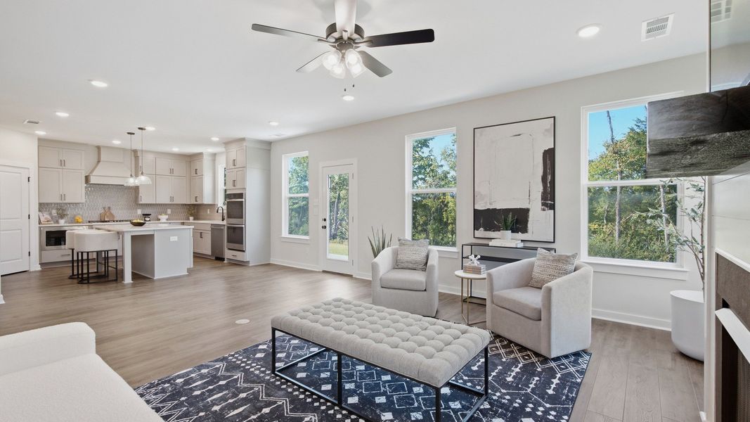 View of living area from back wall showing kitchen and dining areas