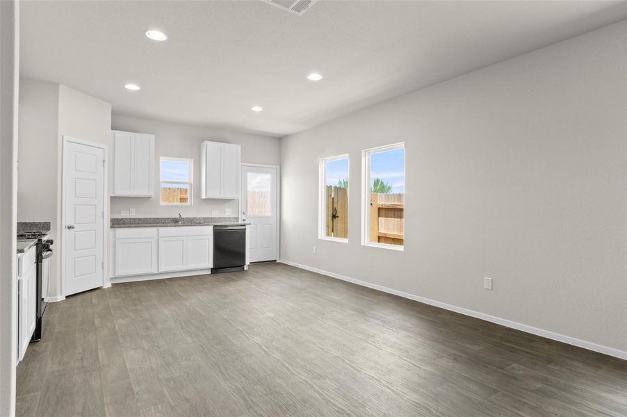 Kitchen featuring healthy amount of natural light, wood finished floors, recessed lighting, and range with gas cooktop Kitchen featuring healthy amount of natural light, wood finished floors, recessed lighting, and range with gas cooktop