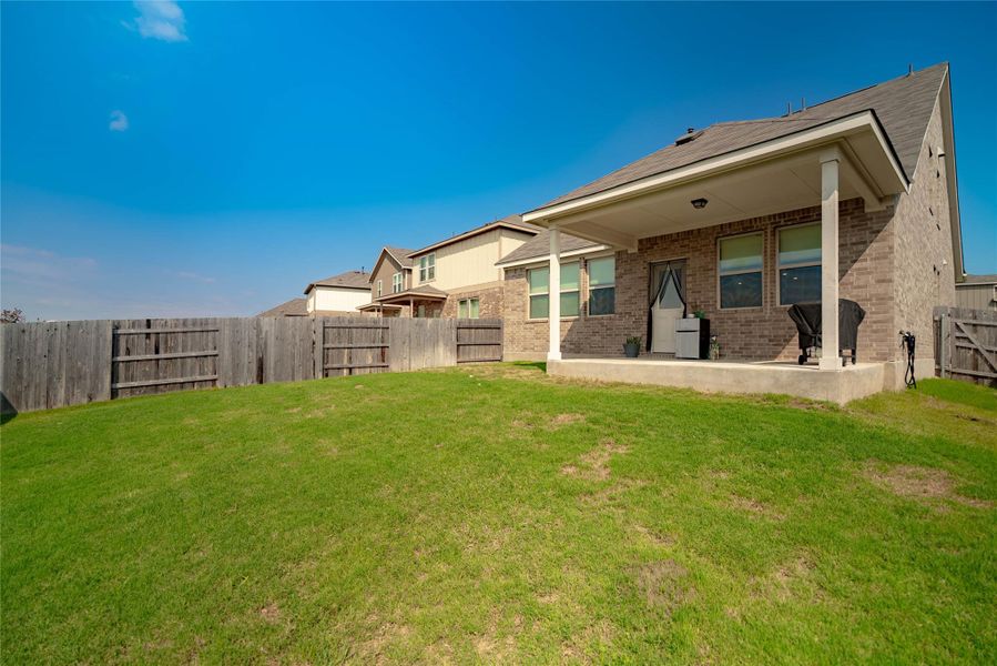 Back of property with a fenced backyard, a patio, and brick siding Back of property with a fenced backyard, a patio, and brick siding