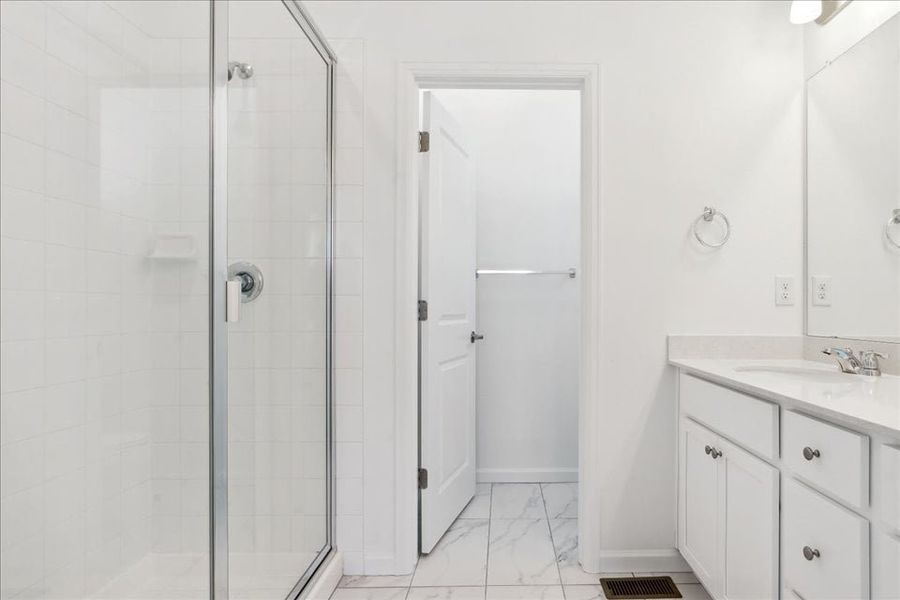 A bathroom with a shower unit and a sink.