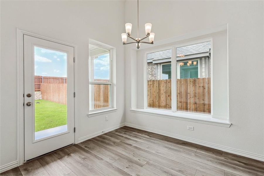 Unfurnished dining area with a chandelier and wood-type flooring