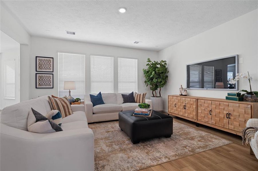 Gather the family and guests together in your lovely family room! Featuring high ceilings, recessed lighting, custom paint, gorgeous vinyl plank flooring and large windows that provide plenty of natural lighting throughout the day.