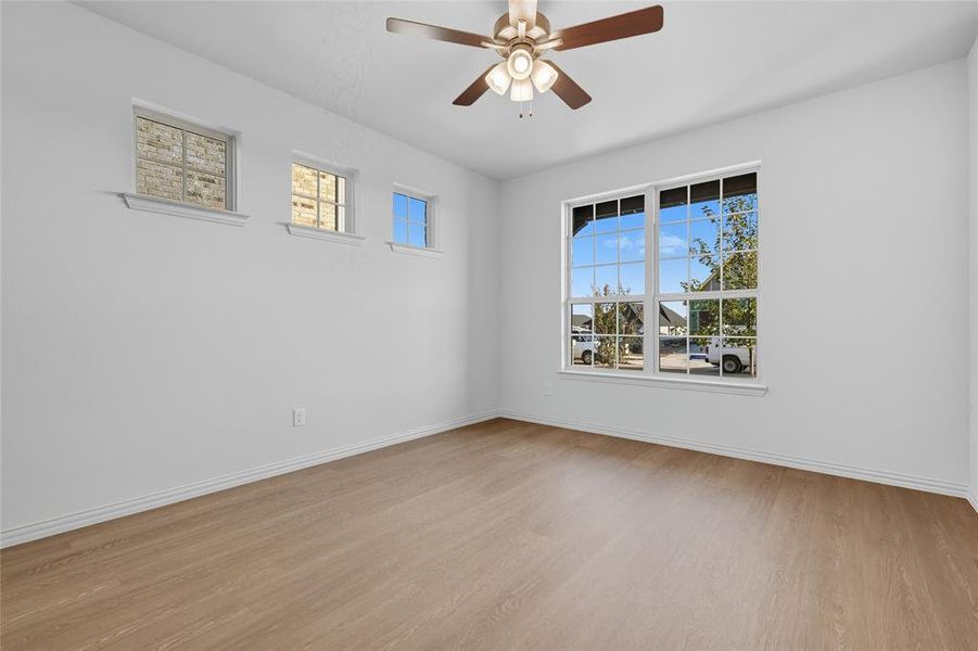 Unfurnished room featuring light wood finished floors and ceiling fan Unfurnished room featuring light wood finished floors and ceiling fan