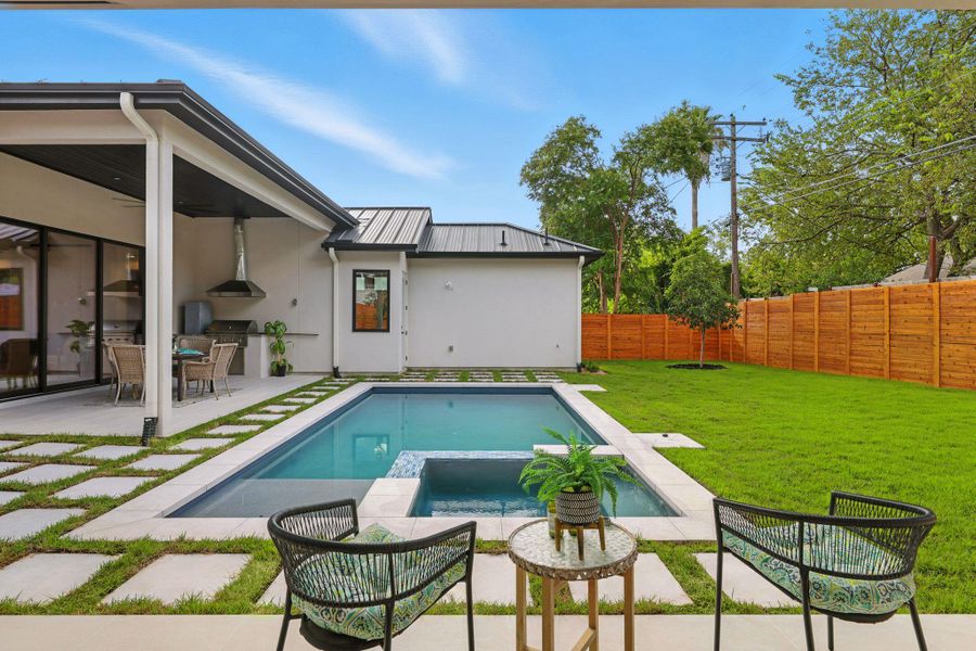 View of pool featuring area for grilling, a fenced backyard, a patio, and a pool with connected hot tub View of pool featuring area for grilling, a fenced backyard, a patio, and a pool with connected hot tub
