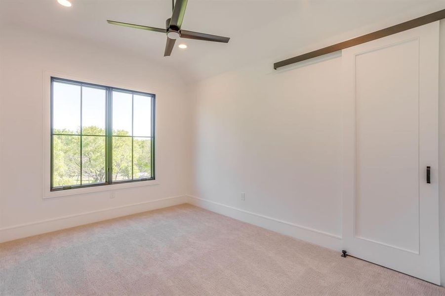 Unfurnished bedroom featuring recessed lighting, light carpet, a ceiling fan, and lofted ceiling