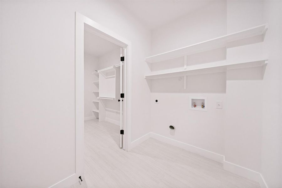 A dedicated laundry space and an adjacent walk-in closet offer practical home organization. A dedicated laundry space and an adjacent walk-in closet offer practical home organization.