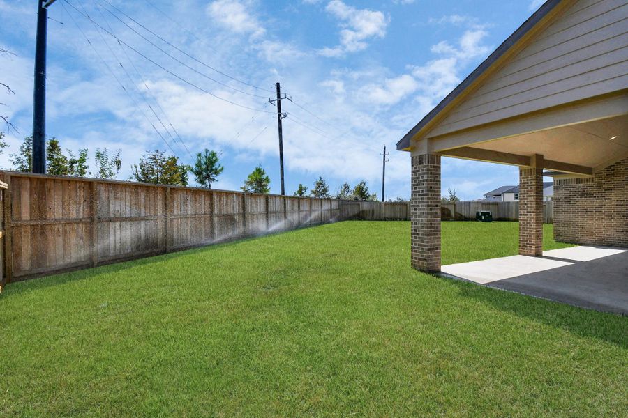 Experience outdoor living at its finest on this expansive covered patio, thoughtfully designed for BBQs and delightful outdoor dining. Sample photo of completed home with similar floor plan. Actual colors and selections may vary.