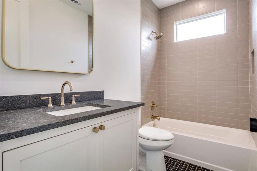 Full bath featuring tile patterned floors, visible vents, toilet, vanity, and shower / bathing tub combination