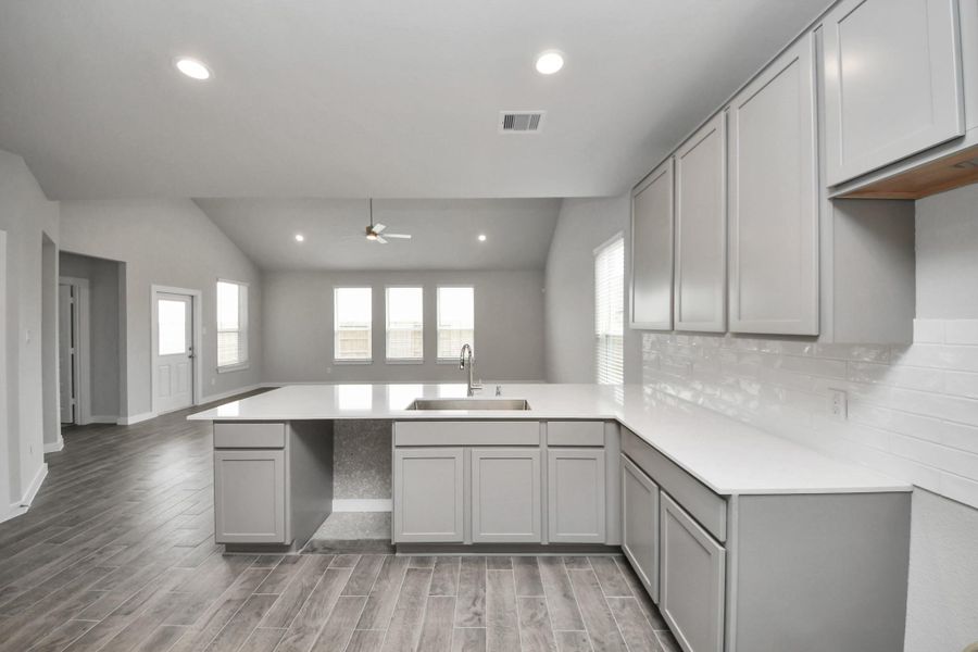 This kitchen is by far any chef’s dream! This spacious kitchen features high ceilings, lightstained wood cabinets, granite countertop, SS appliances, modern tile backsplash,recessed lighting, extended counter space, andspace for breakfast bar, and a walk-in pantry all overlooking your huge family room.