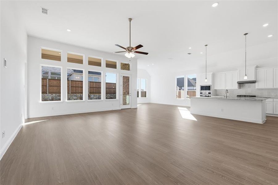 Unfurnished living room featuring dark wood-style flooring, a ceiling fan, and recessed lighting Unfurnished living room featuring dark wood-style flooring, a ceiling fan, and recessed lighting