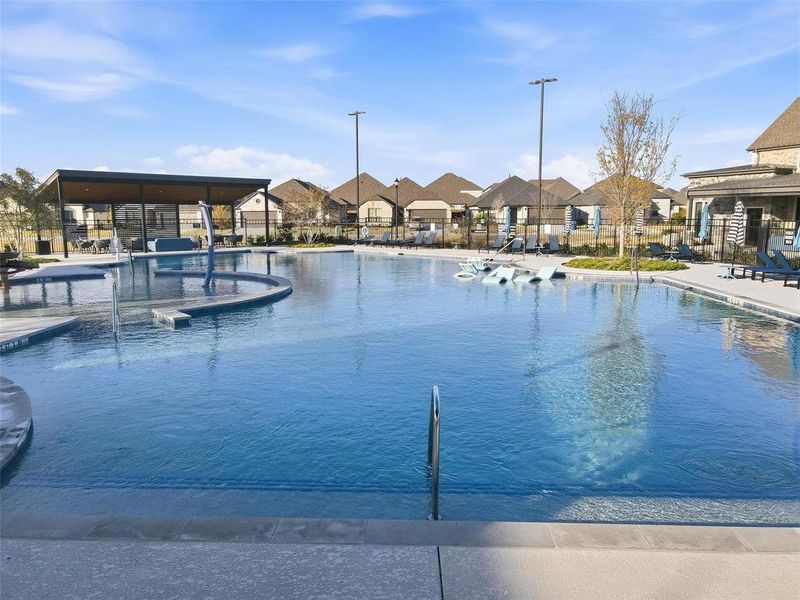 Community pool with a patio and a residential view