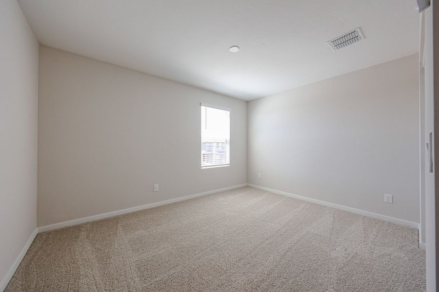 A room with a carpet and a window.