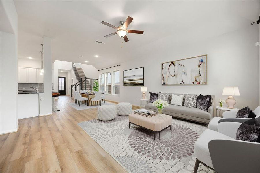 This living room is more like a GREAT room featuring high ceilings, dark stained ceiling fan, and plenty of windows providing a lovely view of your backyard to keep an eye out on the kids or pets playing.