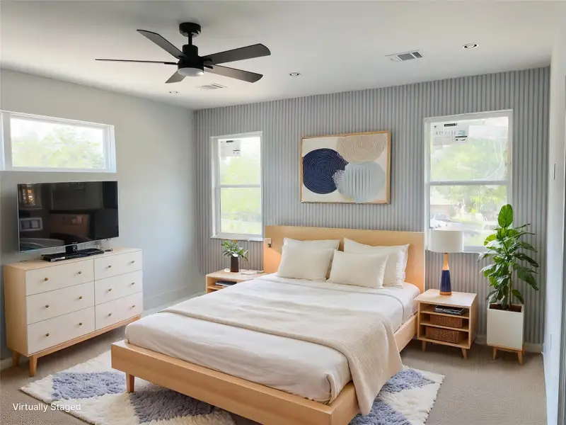 Bedroom featuring wallpapered walls, baseboards, light colored carpet, and a ceiling fan Bedroom featuring wallpapered walls, baseboards, light colored carpet, and a ceiling fan