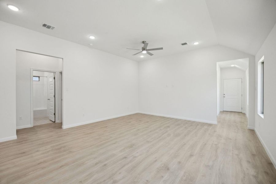 Empty room with a ceiling fan, light wood-style flooring, recessed lighting, and lofted ceiling