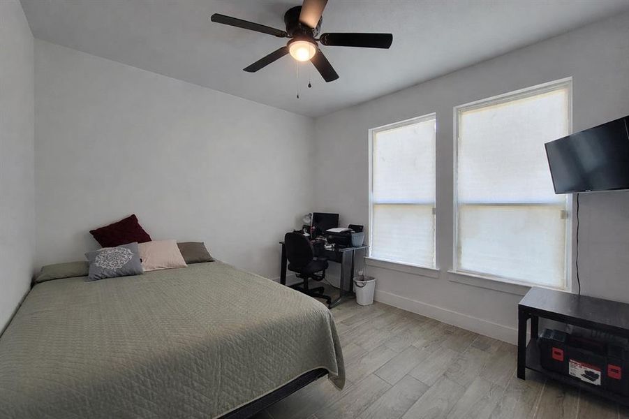 Bedroom featuring light wood-type flooring, ceiling fan, and a desk Bedroom featuring light wood-type flooring, ceiling fan, and a desk