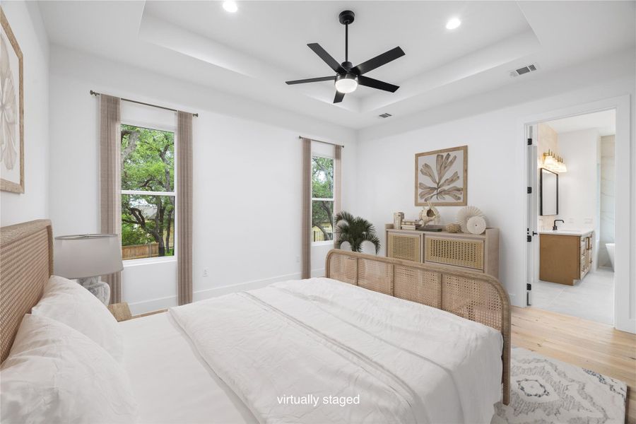 Bedroom with a tray ceiling, wood finished floors, ceiling fan, and recessed lighting.Virtually staged. Bedroom with a tray ceiling, wood finished floors, ceiling fan, and recessed lighting.Virtually staged.