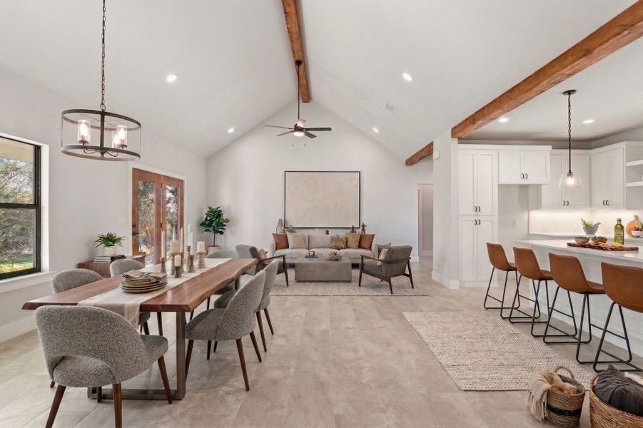 An open-concept living space with exposed beams and a seamless flow from dining to kitchen. An open-concept living space with exposed beams and a seamless flow from dining to kitchen.