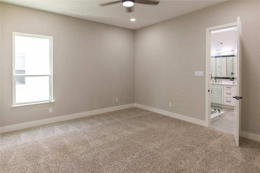 Carpeted empty room featuring ceiling fan