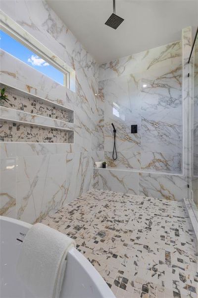 Full bath with a marble finish shower and tile walls