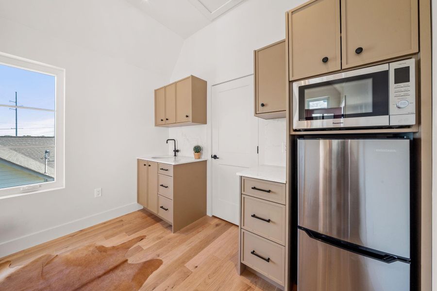 Detached studio space has a kitchenette with refrigerator/freezer,  smart multi-oven, and sink.