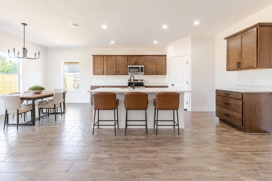 The oversized island earns its keep: bar seating, prep space, and a natural landing spot between the kitchen and dining area. The oversized island earns its keep: bar seating, prep space, and a natural landing spot between the kitchen and dining area.