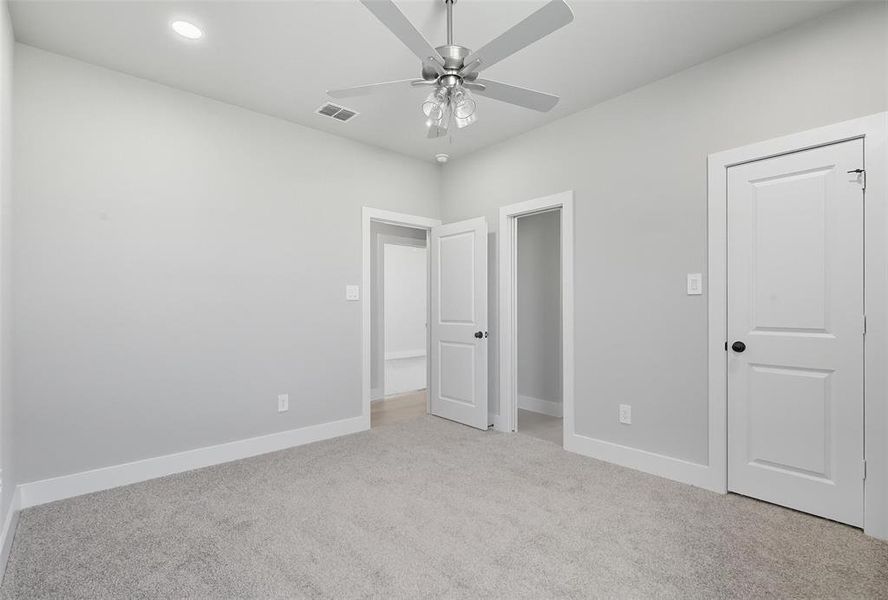 Unfurnished bedroom featuring light colored carpet, a ceiling fan, and recessed lighting