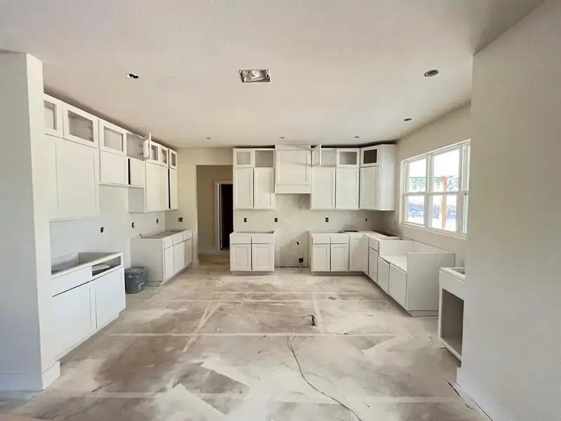 Kitchen with white cabinetry and glass insert cabinets