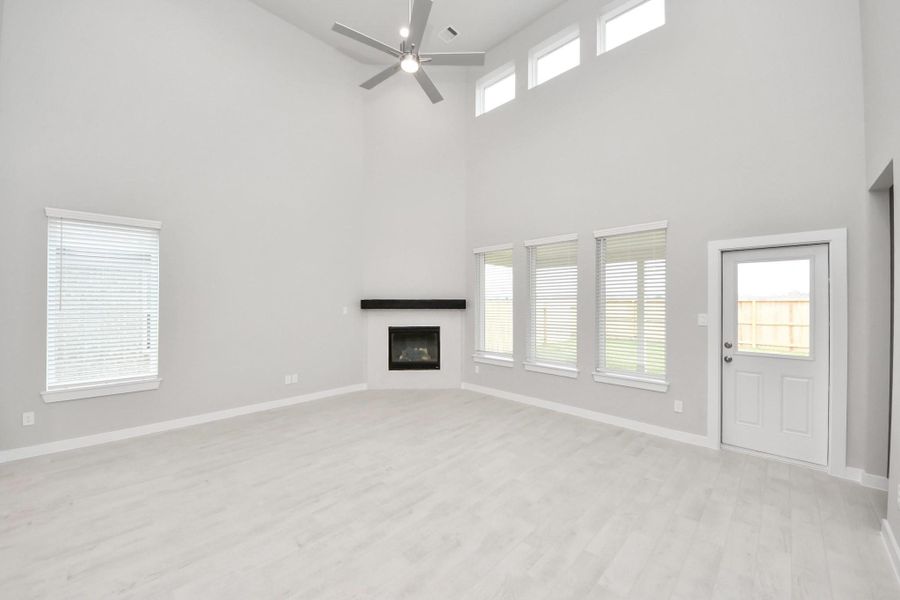 Welcome family and guests to your charming living room! With its high ceilings, recessed lighting, ceiling fan, custom paint, beautiful flooring, and large windows that let in abundant natural light, this room is perfect for gatherings. Sample photo of completed home with similar floor plan. Actual colors and selections may vary. Welcome family and guests to your charming living room! With its high ceilings, recessed lighting, ceiling fan, custom paint, beautiful flooring, and large windows that let in abundant natural light, this room is perfect for gatherings. Sample photo of completed home with similar floor plan. Actual colors and selections may vary.