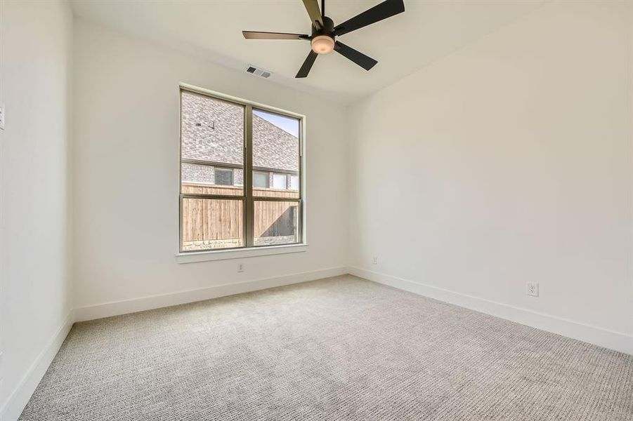 Spare room featuring carpet and ceiling fan