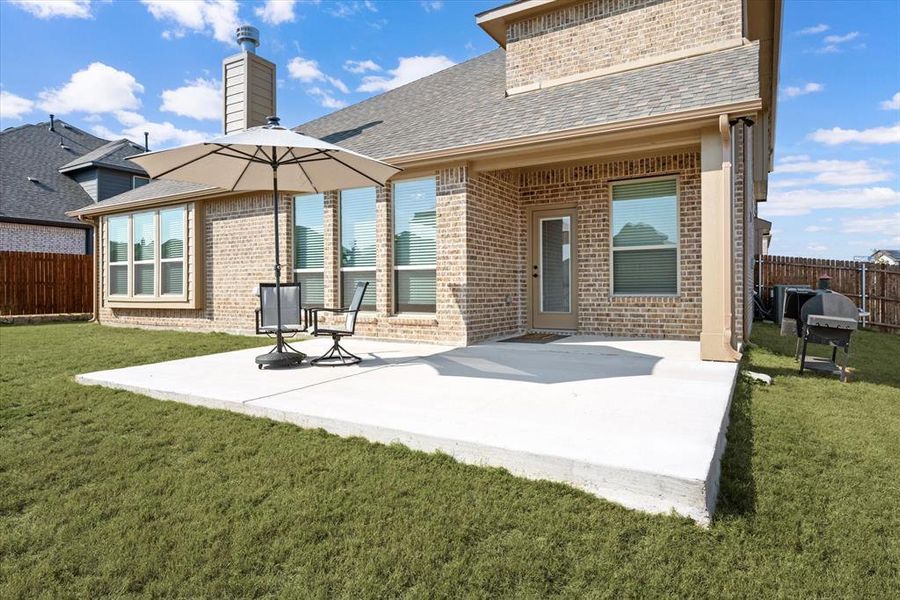 Rear view of this all brick, energy efficient home with an extended patio area and big backyard