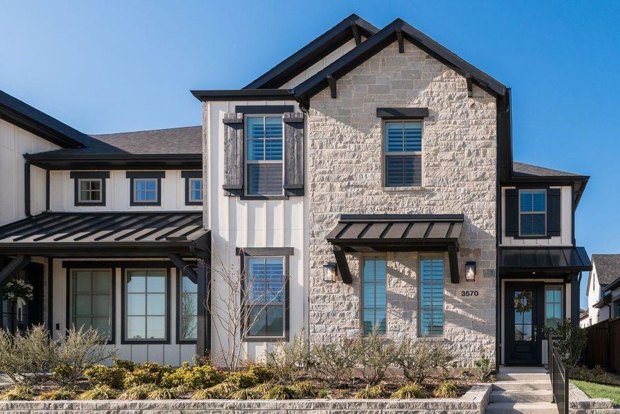 View of front facade with a standing seam roof, stone siding, and board and batten siding