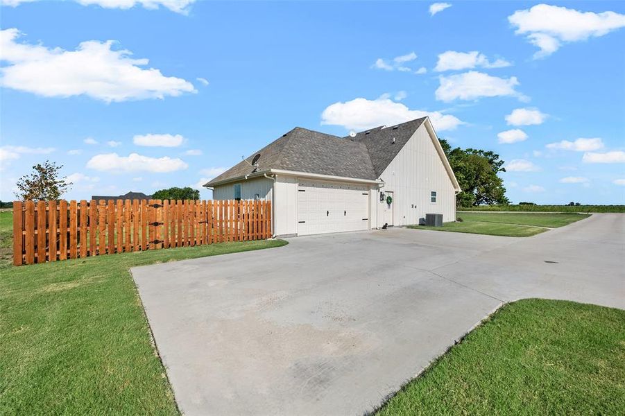 View of home's exterior with a side entry garage and a lawn