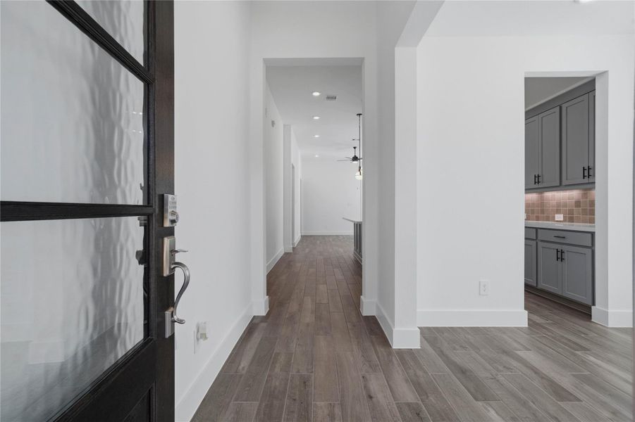 Step into elegance through a grand foyer that immediately sets a sophisticated tone with pristine white walls and premium wood-look flooring. Step into elegance through a grand foyer that immediately sets a sophisticated tone with pristine white walls and premium wood-look flooring.