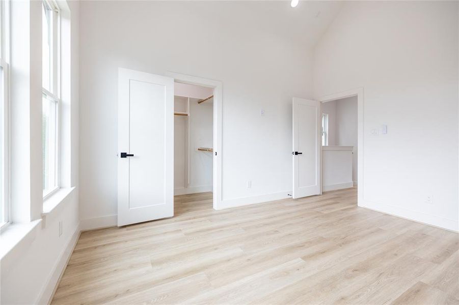 Alternate angle of the primary bedroom showcases one of two walk-in closets, offering plenty of storage for your needs.