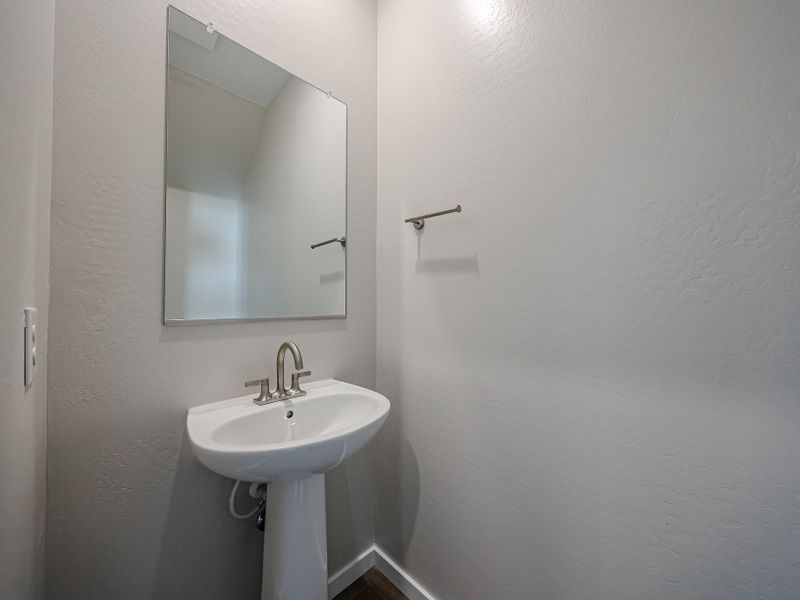 A bathroom with a mirror and sink.