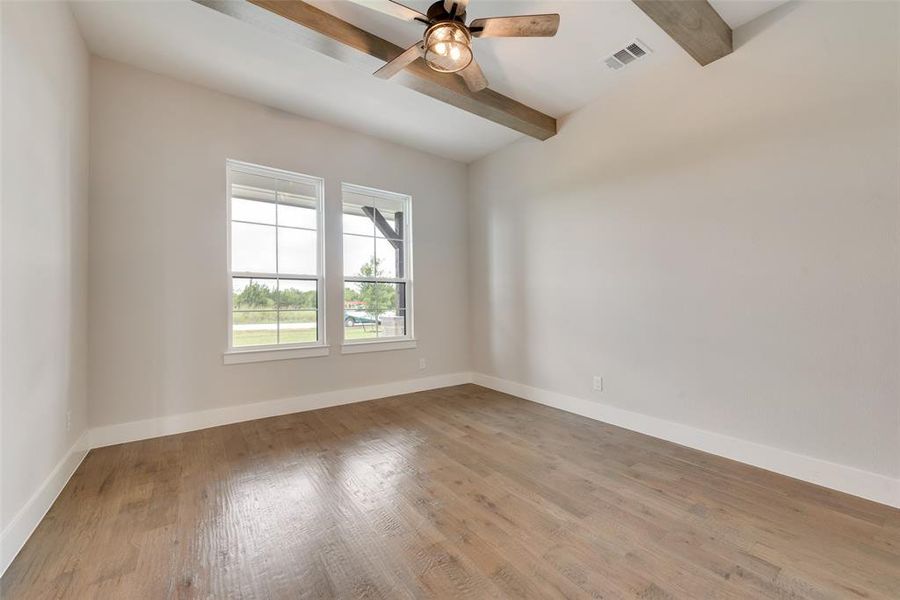 Spare room with beamed ceiling, hardwood / wood-style flooring, and ceiling fan