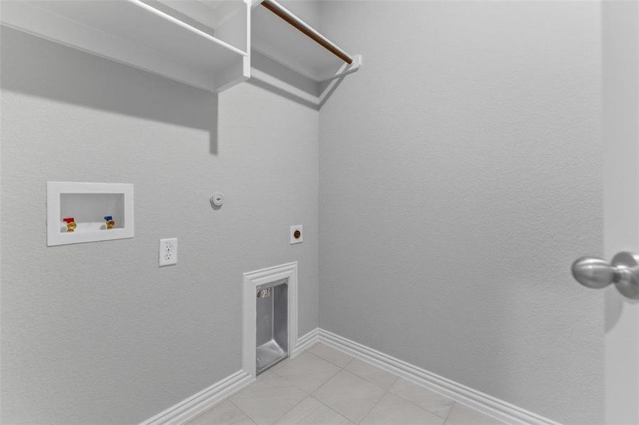 Laundry area with hookup for a gas dryer, washer hookup, hookup for an electric dryer, and light tile patterned flooring