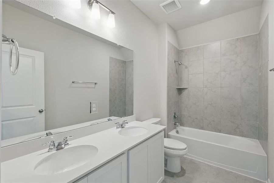 Full bath with shower / washtub combination, double vanity, light tile patterned floors, and recessed lighting