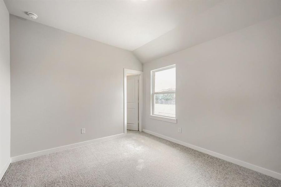 Bright room featuring light grey carpeting, white baseboards, and a single window with white trim