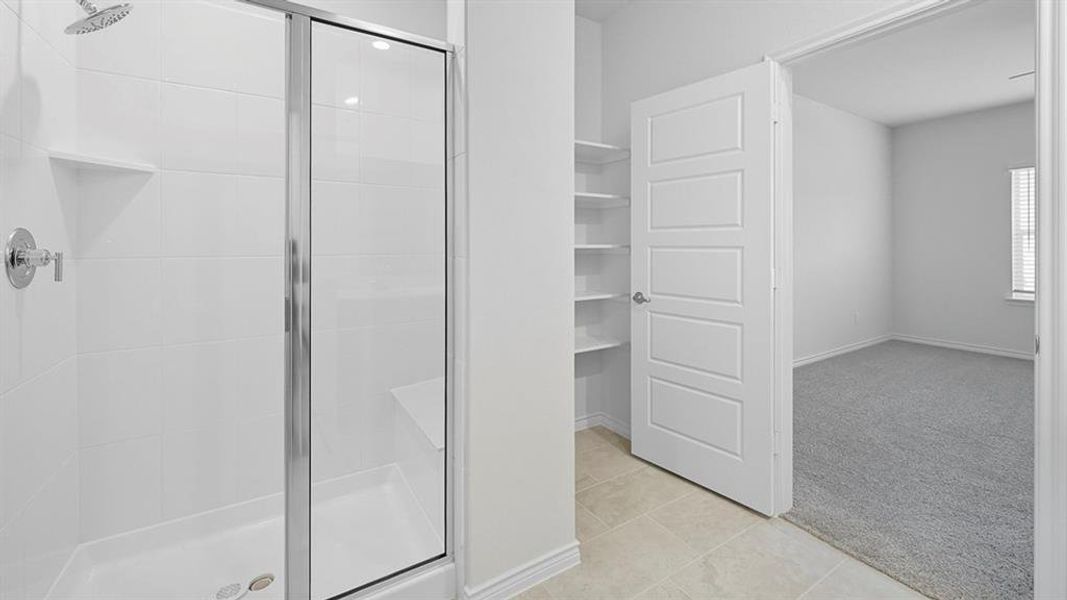 Full bathroom with a shower stall, light carpet, and light tile patterned floors