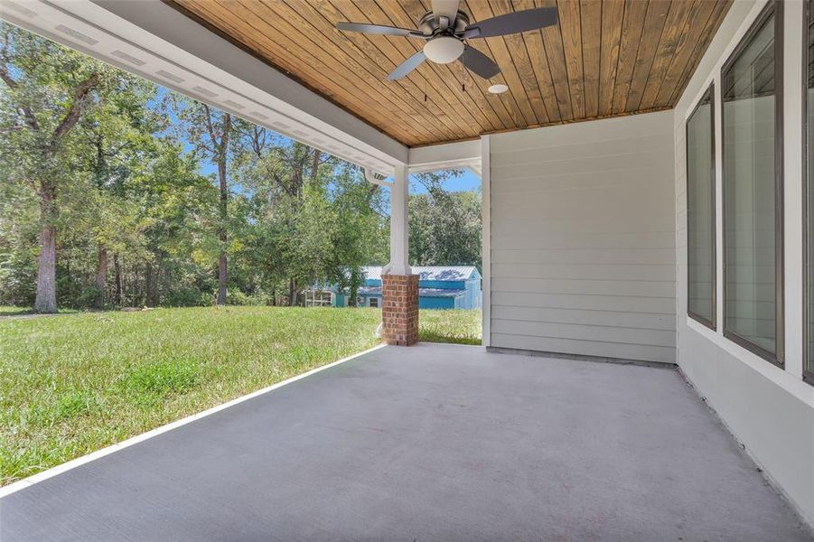 Large back porch with planked ceiling and fan