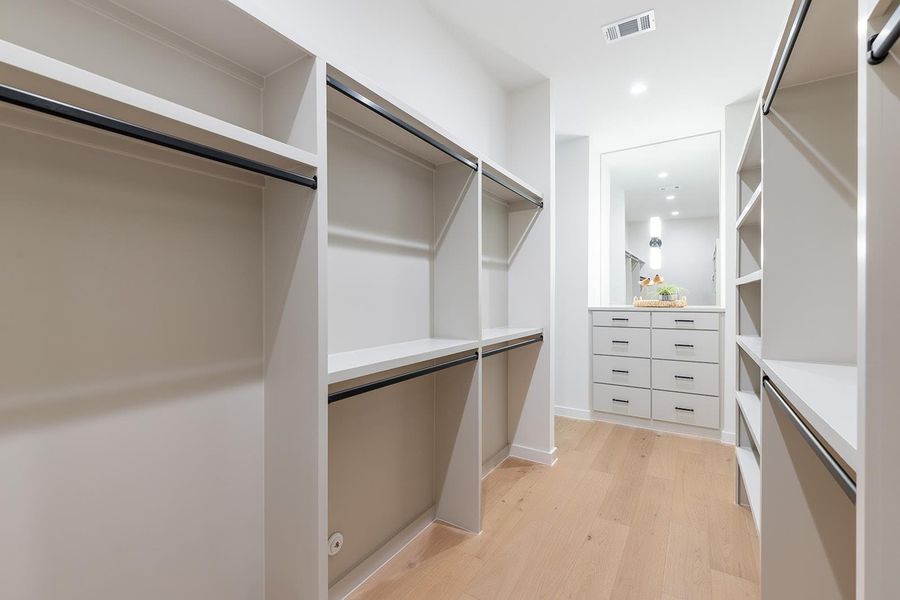 Walk in closet with light wood-style flooring