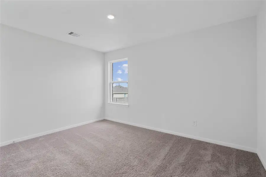 This secondary bedroom offers comfort and style with plush carpeting, neutral paint tones, recessed lighting, a large window, and a generously sized closet. This secondary bedroom offers comfort and style with plush carpeting, neutral paint tones, recessed lighting, a large window, and a generously sized closet.