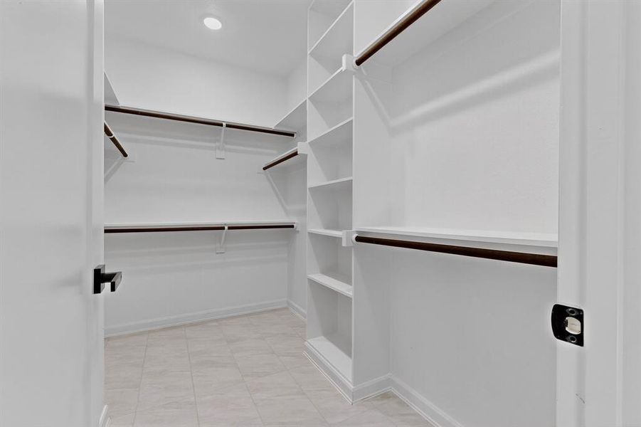 Walk in closet with light tile patterned flooring Walk in closet with light tile patterned flooring