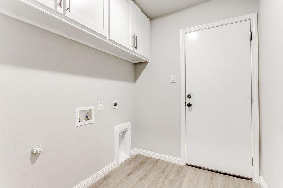 Laundry area featuring hookup for an electric dryer, light hardwood / wood-style floors, cabinets, and washer hookup