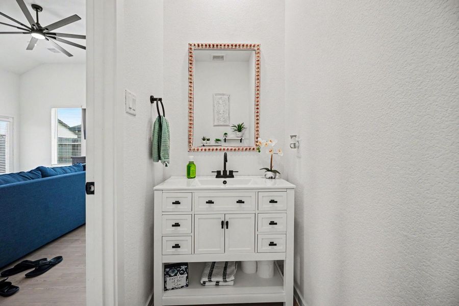 Convenient first-floor half bathroom featuring an updated vanity and modern fixtures. Convenient first-floor half bathroom featuring an updated vanity and modern fixtures.