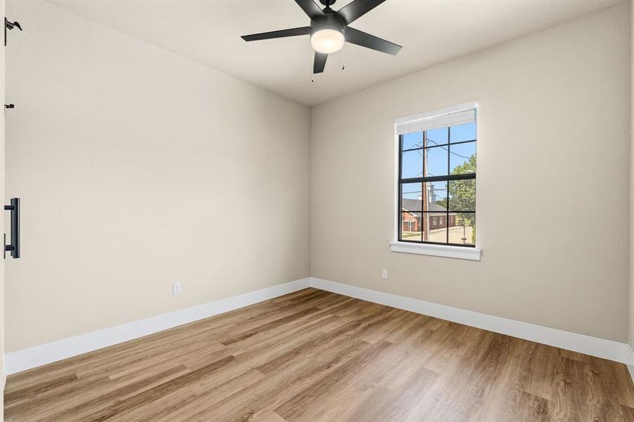 Bedroom #2 Upstairs with wood-finish flooring, a contemporary ceiling fan with integrated lighting, and a single window featuring a white blind