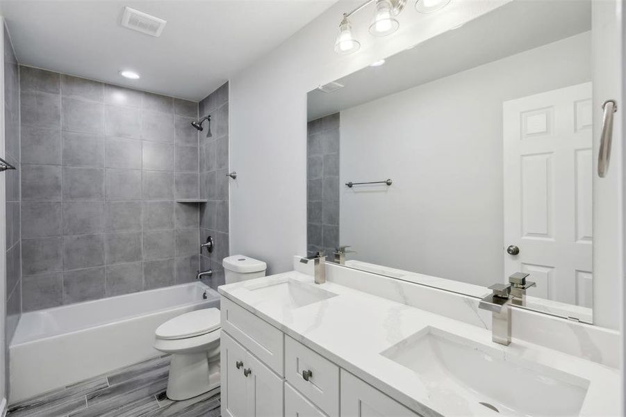 Full bathroom with vanity, toilet, and tiled shower / bath