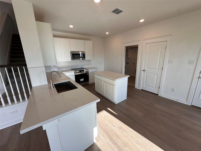Kitchen featuring white cabinetry, recessed lighting, appliances with stainless steel finishes, and dark wood-style flooring Kitchen featuring white cabinetry, recessed lighting, appliances with stainless steel finishes, and dark wood-style flooring